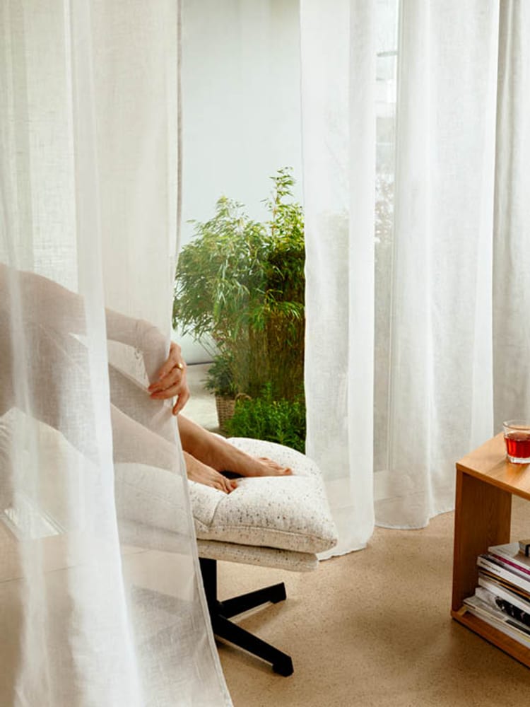 Entspannter Moment hinter weissen Tagvorhängen.