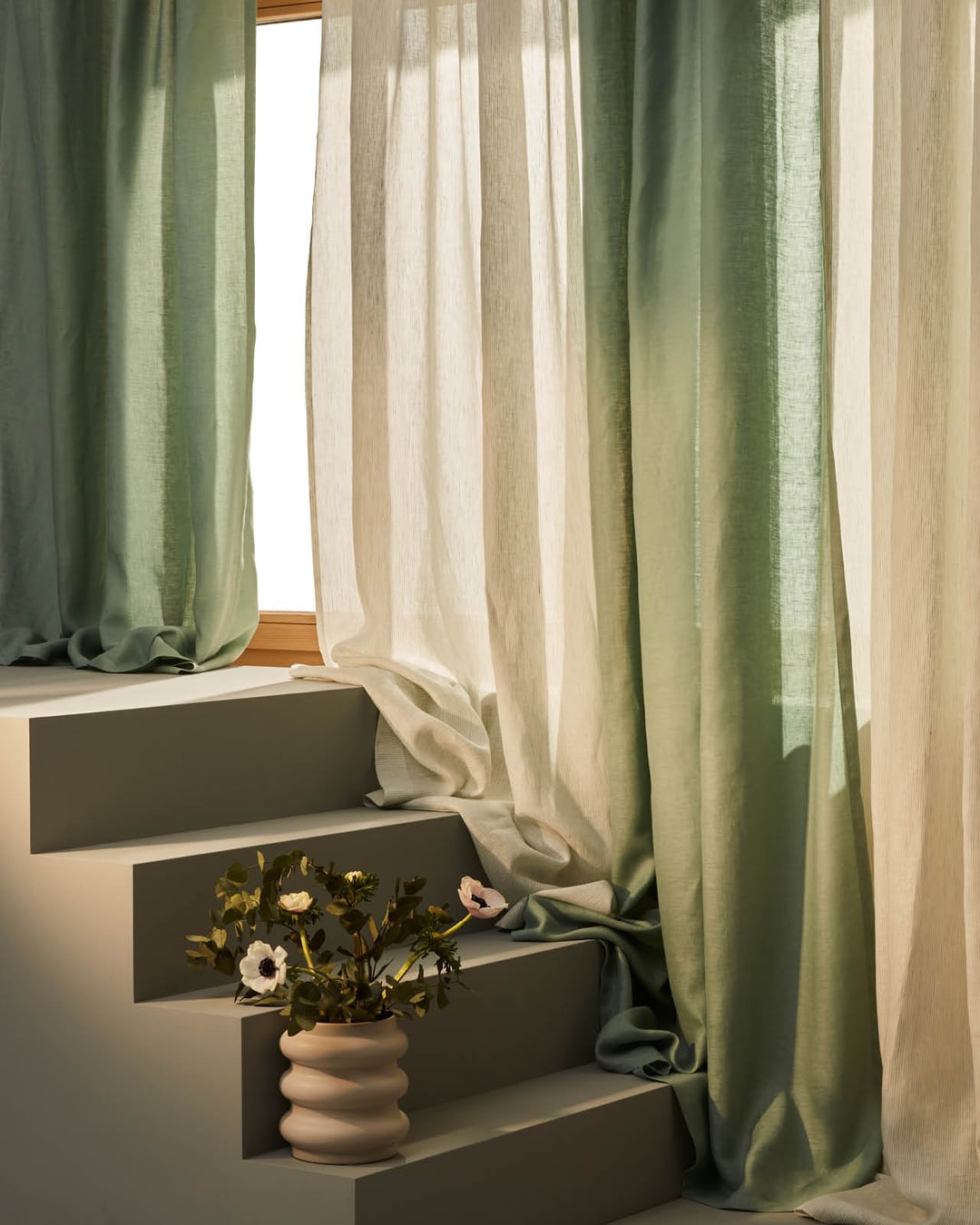 Tende illuminate in tonalità verdi e beige, decorate con un vaso e fiori su una scala.