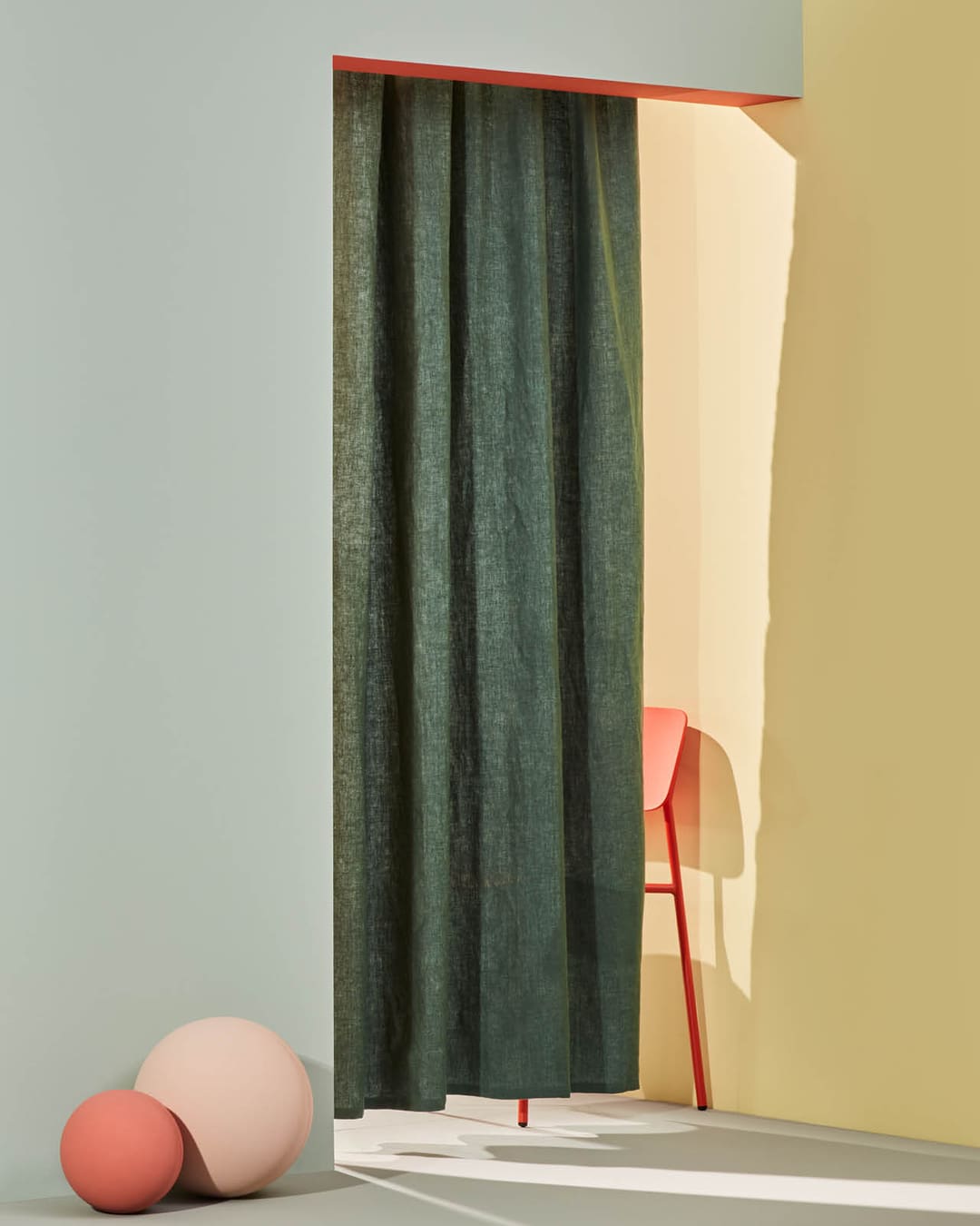 Blickdichter Vorhang vor einem roten Stuhl.