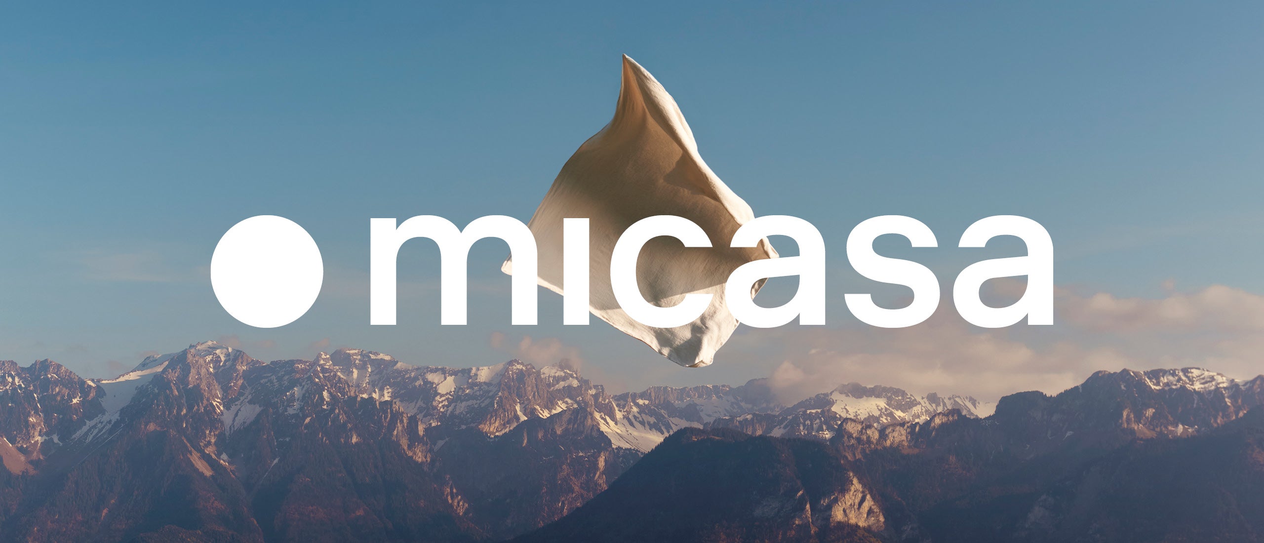 Micasa-Logo vor einer Berglandschaft mit schwebender Bettwaesche.