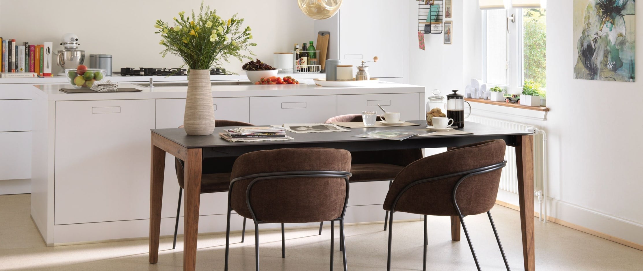 Une table avec des chaises dans une cuisine lumineuse et ouverte