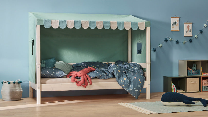 Kinderbett mit Stoffdach in Mint und blauer Bettwäsche in maritimem Design in einem liebevoll dekorierten Kinderzimmer.