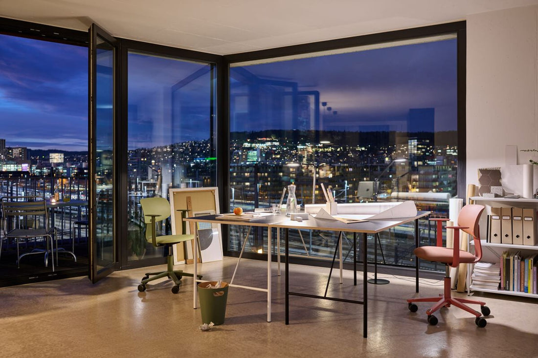 Abendstimmung in einem modernen Arbeitszimmer mit grossen Fensterfronten. 