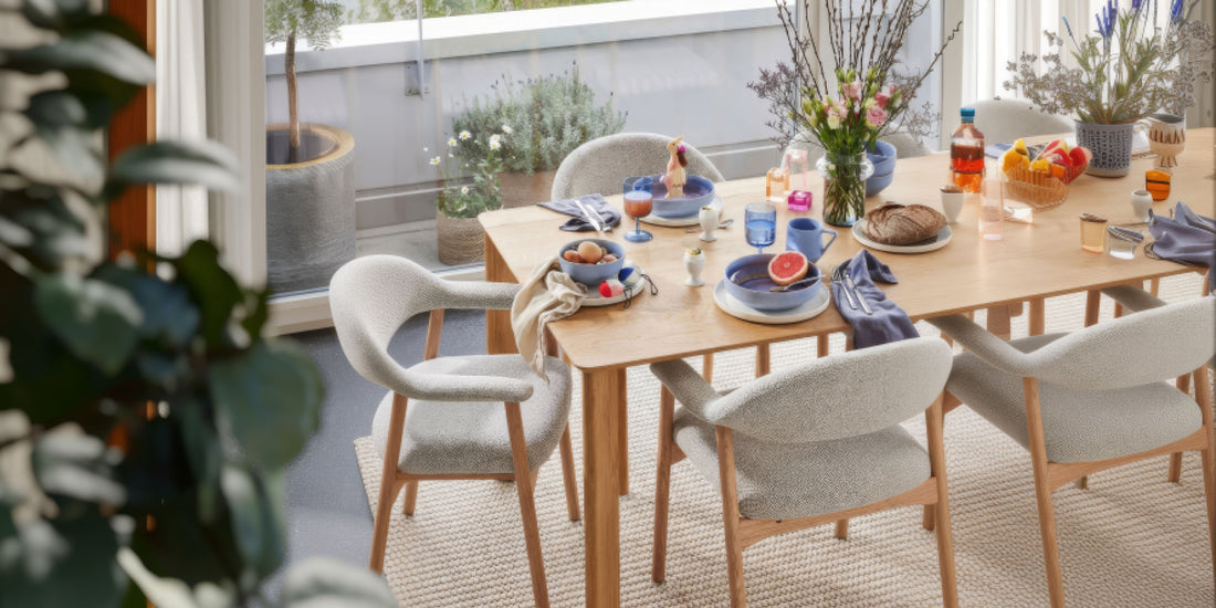 Frühstückstisch mit gedeckter Tafel, gepolsterten Esszimmerstühlen und Blumenarrangement