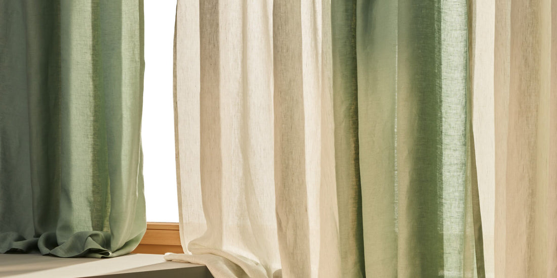 Transparente Vorhänge in Natur und Grün vor Fenster mit Holzrahmen.