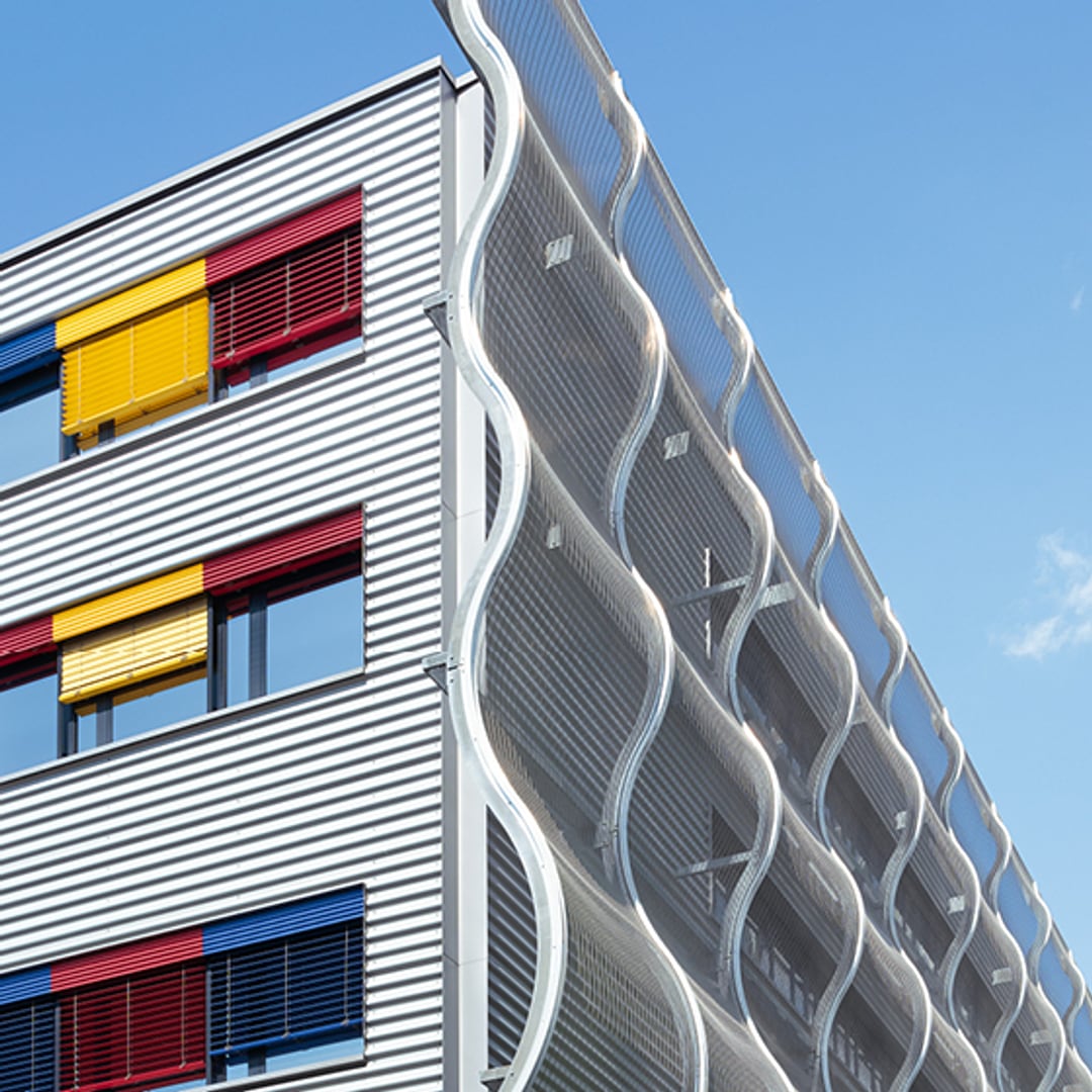 Façade moderne avec des éléments ondulés et des volets colorés.