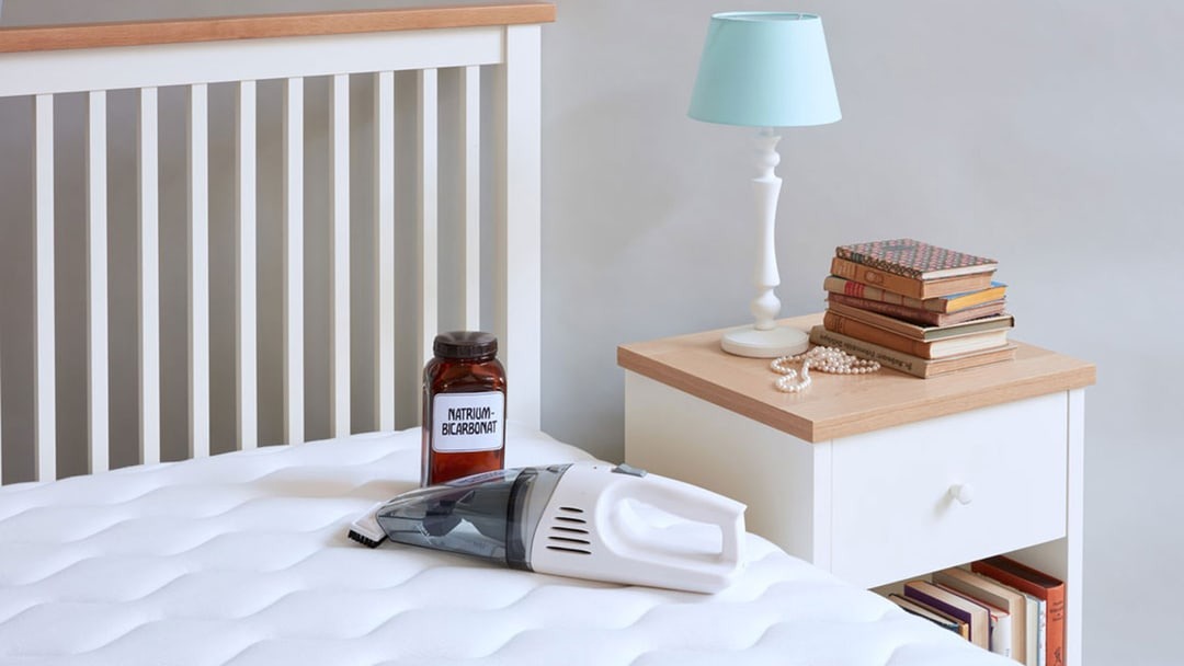 Handstaubsauger auf einer Matratze