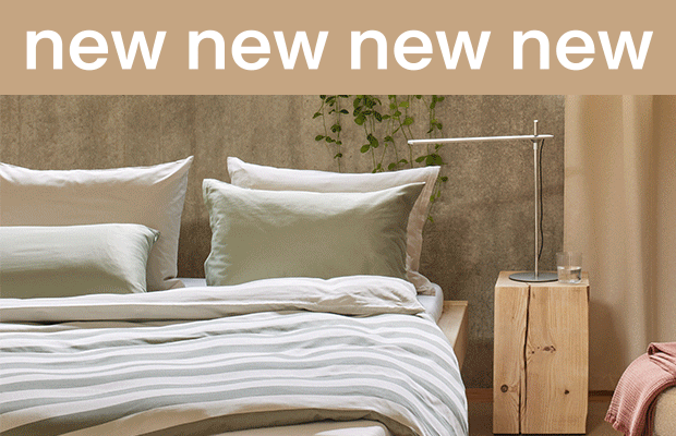 Modernes Schlafzimmer mit Bett und Nachttischlampe.