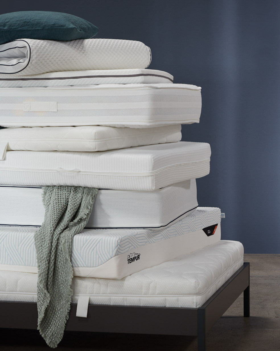 Aufgestappelte Matratzen auf einem Bett